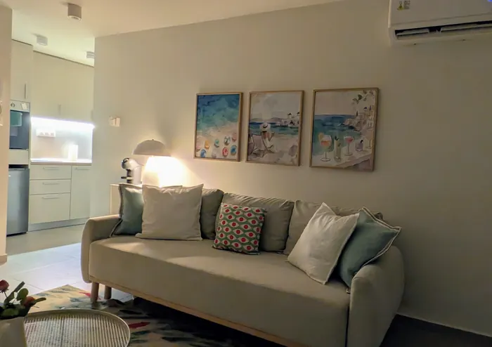 The living room in the evening with soft lamp light and sea-themed prints