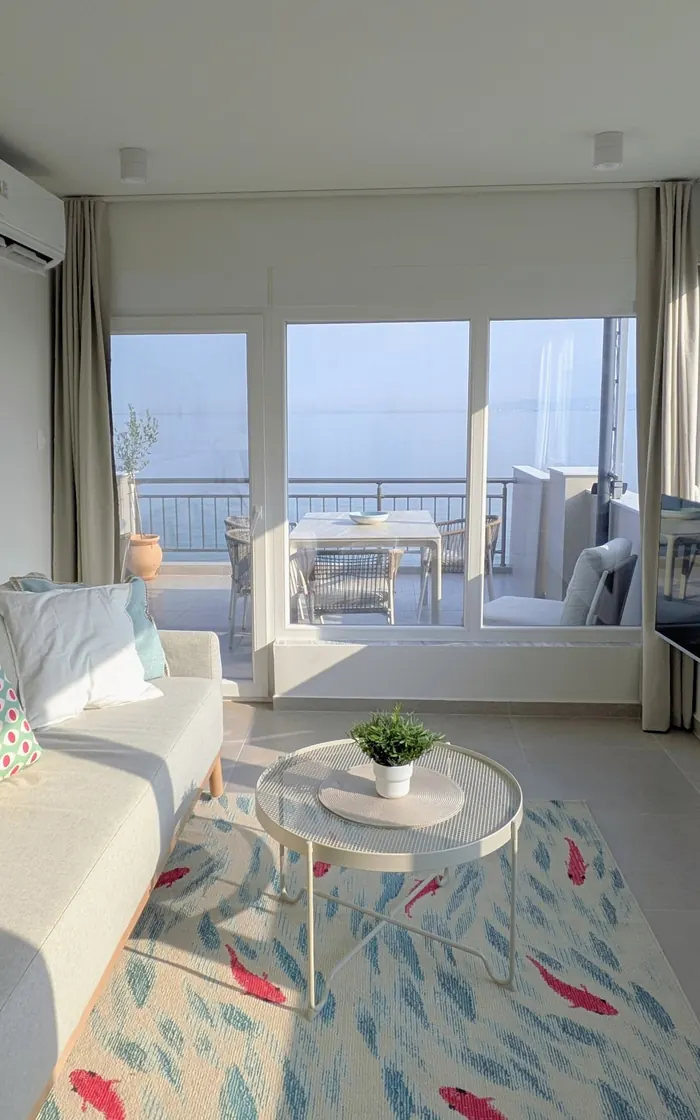 Living area looking out through floor-to-ceiling windows to the terrace and sea