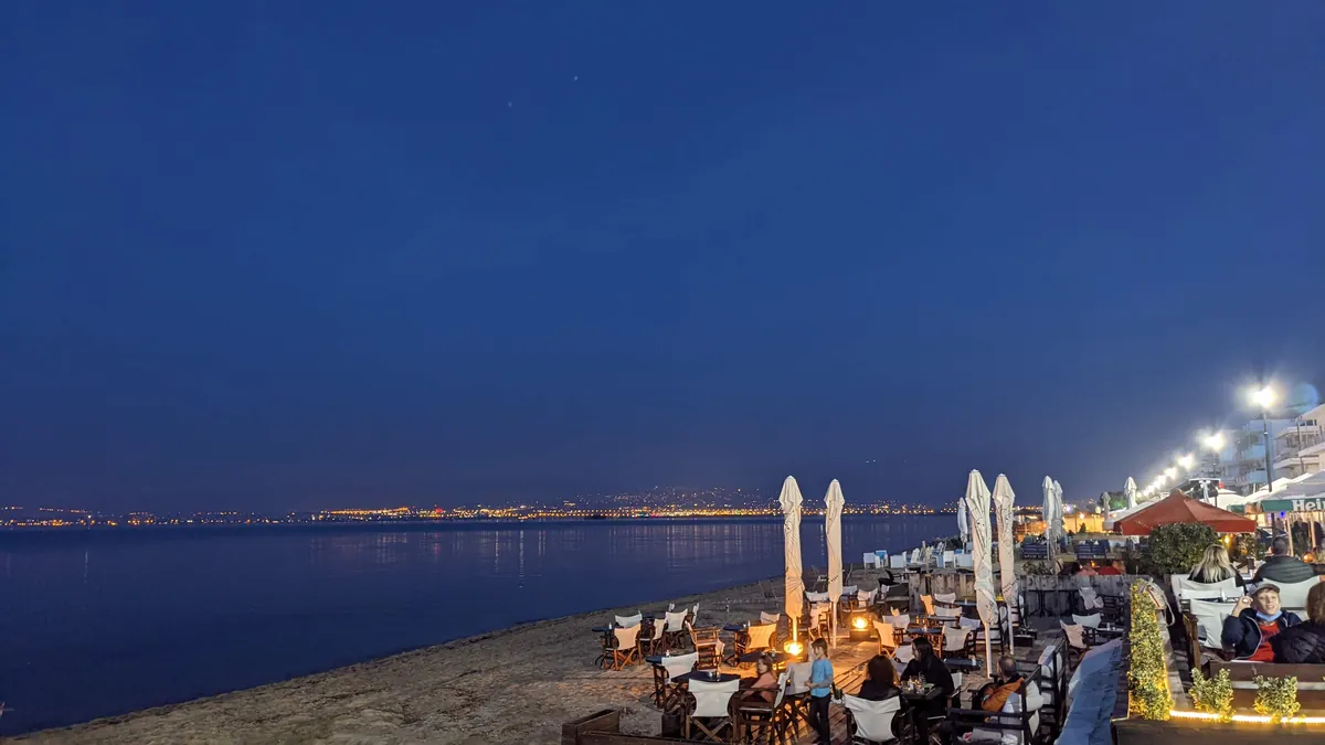 Perea’s beachfront tavernas at blue hour, with Thessaloniki’s lights across the bay