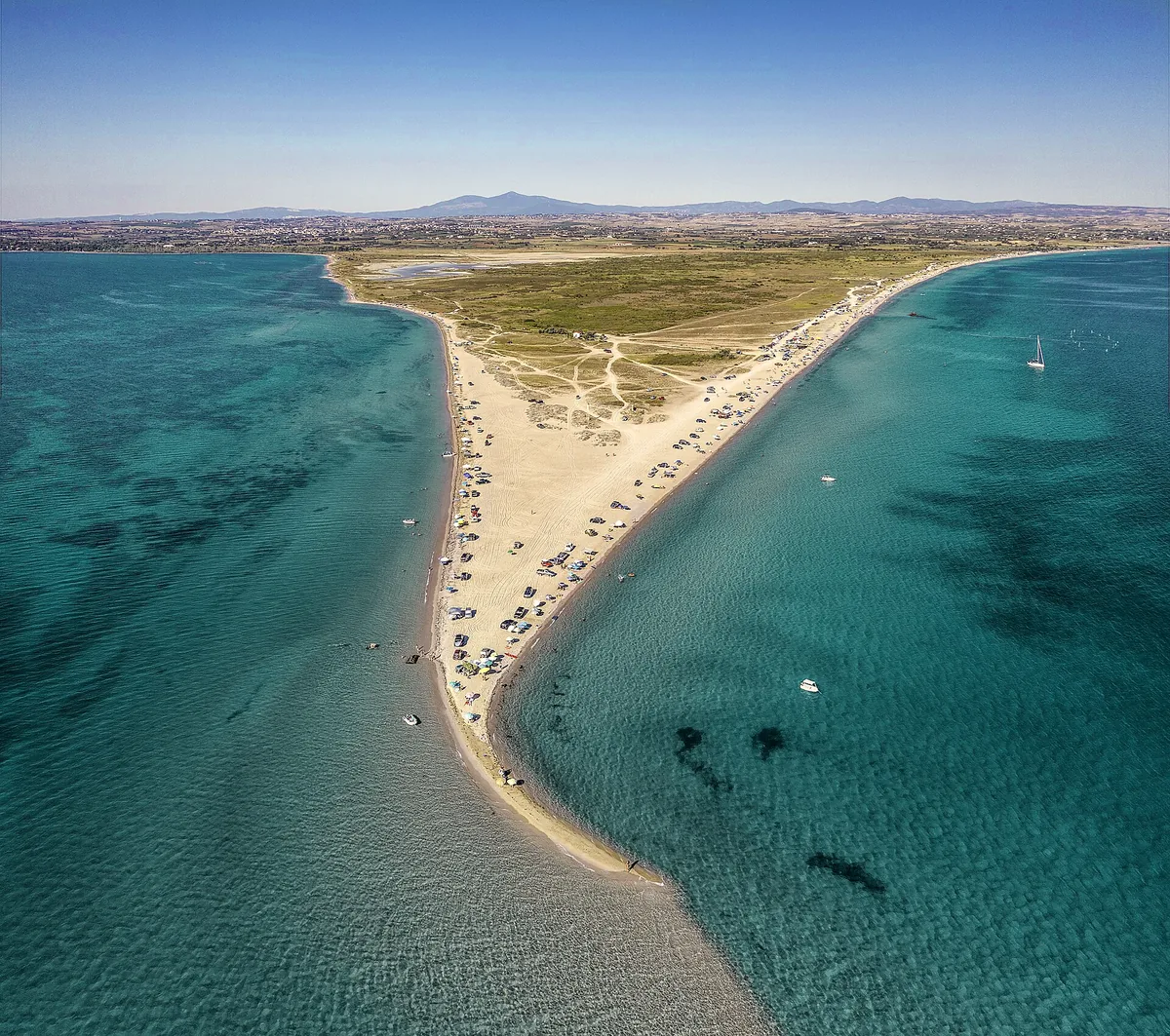 Aerial view of Potamos Beach at Epanomi: a long sandy cape between two turquoise bays