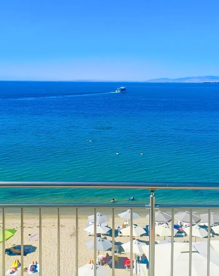 Turquoise sea below the balcony with a boat heading across the bay