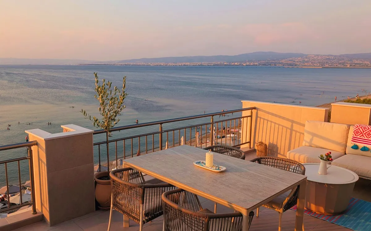 The terrace table in warm evening light above the bay