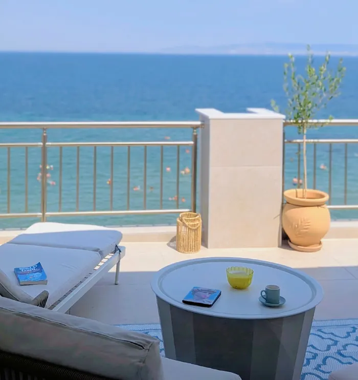 Lounge chairs and a side table by the terrace railing