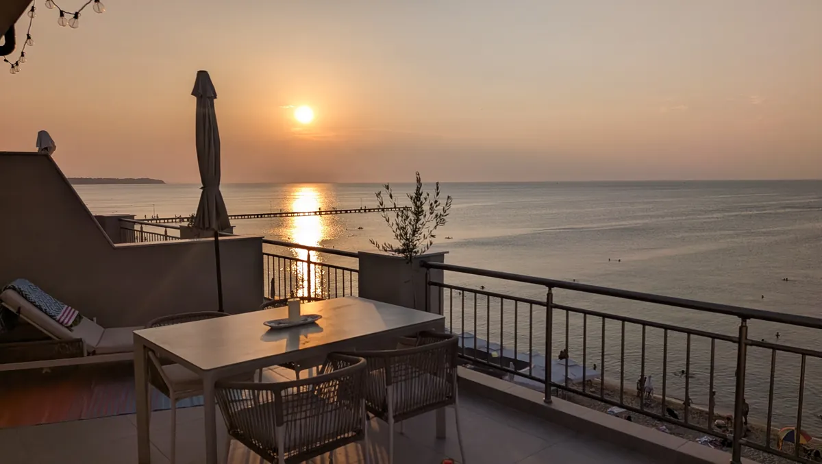 Sunset over the sea from the terrace dining table at The Sunset Terrace